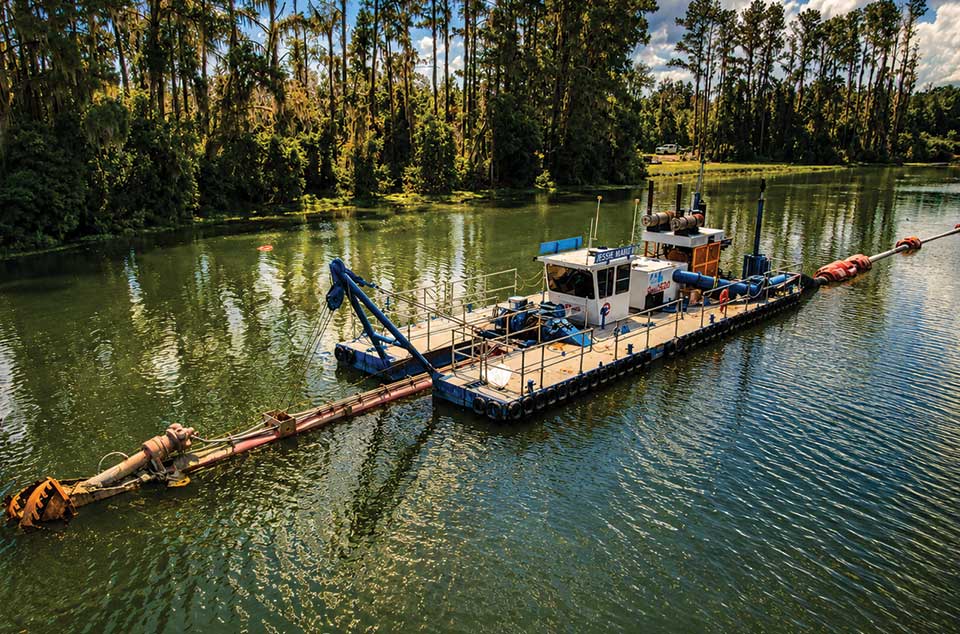 ENVIRONMENTAL-RESTORATION Environmental restoration dredging near a wooded shoreline